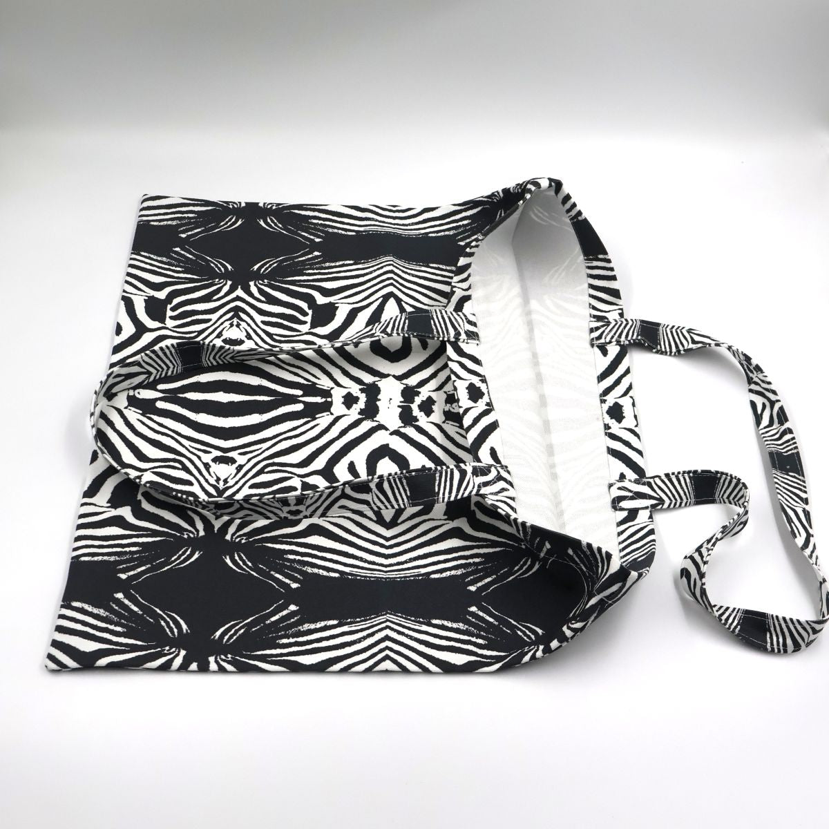 Close up view of quality stitching and finishes on bold black and white zebra canvas tote