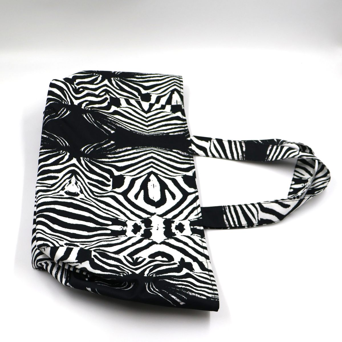 Close up view of sturdy shoulder handles and premium stitching on zebra print teacher book bag