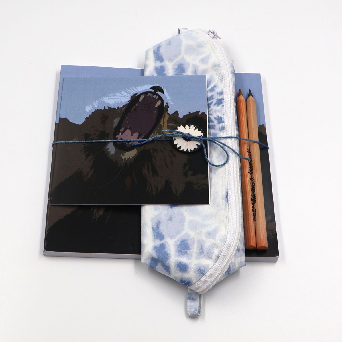 Handmade South African nature gift box neatly arranged with a square yawning lion sketchpad a soft blue giraffe canvas pencil case and a matching animal greeting card